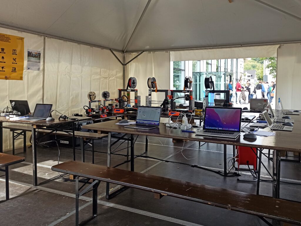 die Workshop Arbeitsfläche mit mehreren Laptops und 3D Druckern